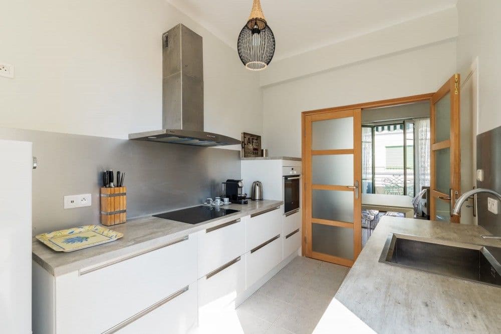 Fitted kitchen with white units and glazed doors, 1-bedroom apartment in central Nice