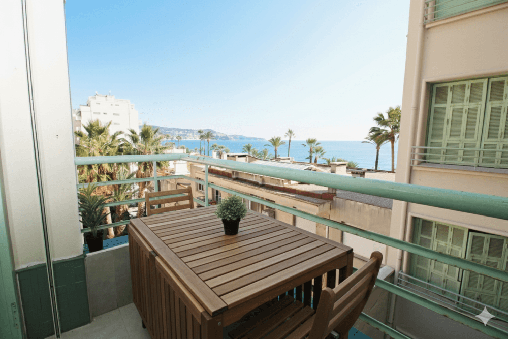 Balcony with wooden dining set and a view of the sea, 2-bedroom apartment in the Promenade des Anglais, Nice