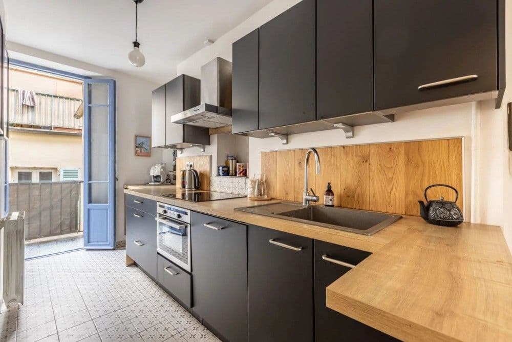 Kitchen with black units, wooden worktop and balcony door, 2-bedroom apartment in the Port, Nice