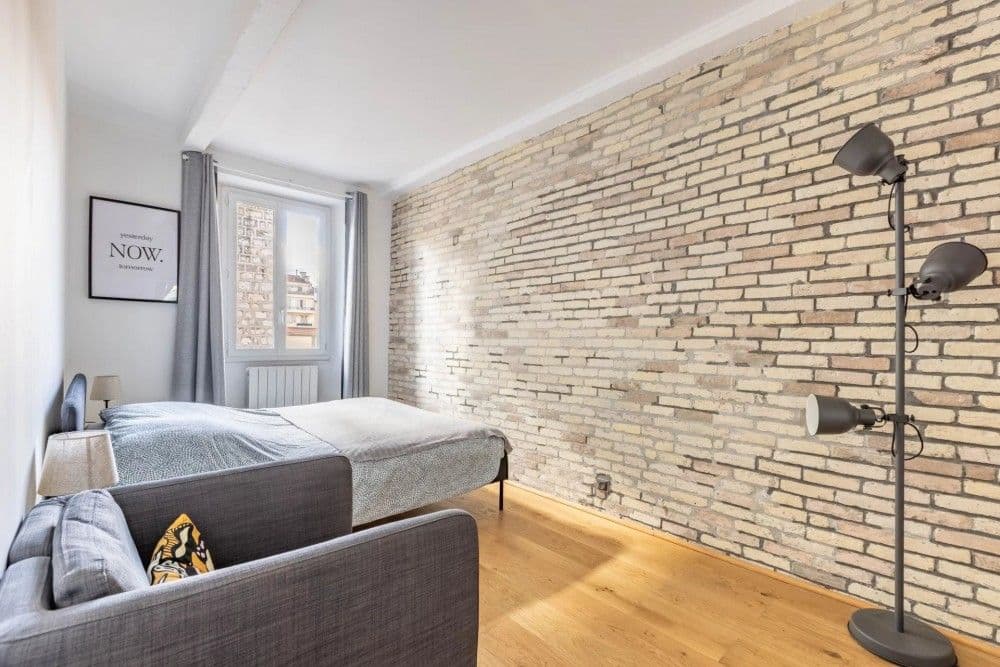 Bedroom with exposed brick wall and oak floor, 2-bedroom apartment in the Port, Nice