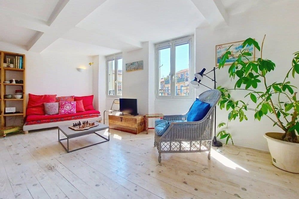 Living room with red sofa, bookcase and tall windows, 2-bedroom apartment in the Port, Nice
