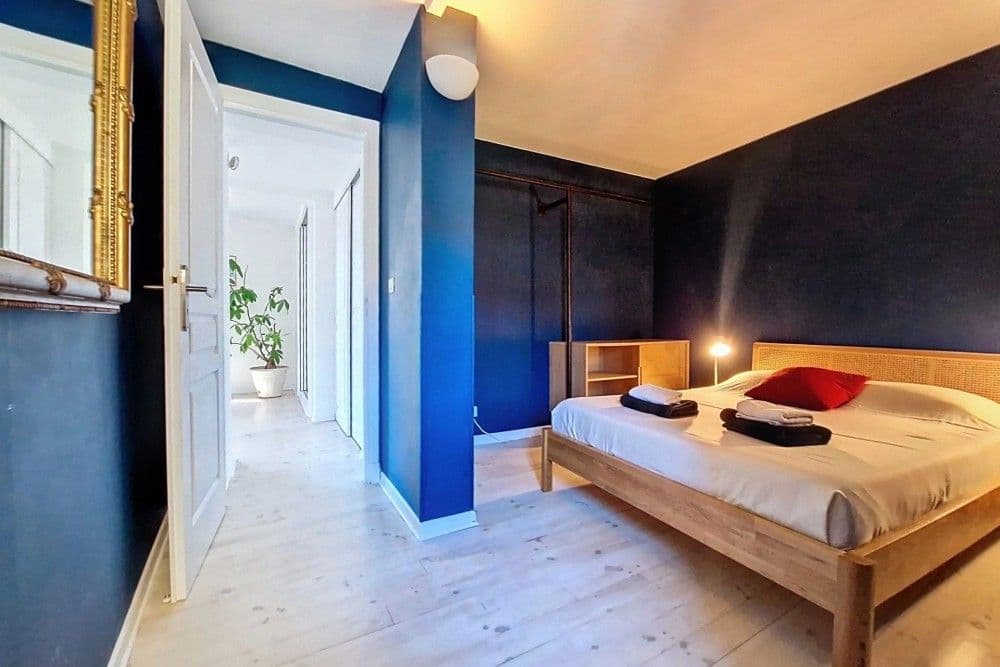 Bedroom with navy feature wall and wooden bed, 2-bedroom apartment in the Port, Nice