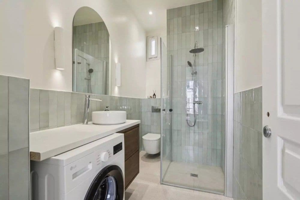 Shower room with green tiles, arched mirror and laundry space, 2-bedroom apartment in central Nice