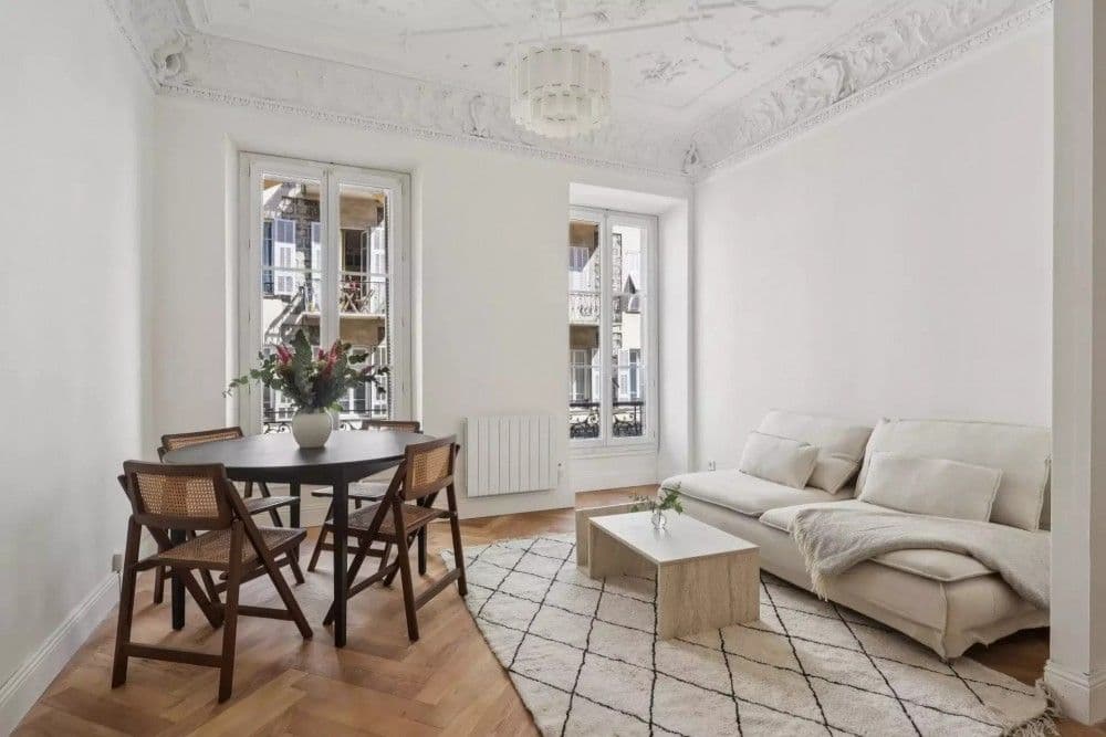 Living room with sofa, round table and ornate ceiling, 2-bedroom apartment in central Nice