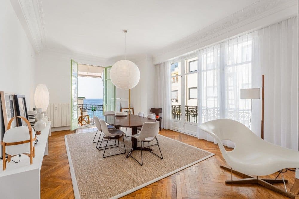 Dining room with herringbone parquet and doors to the balcony, 3-bedroom apartment in the Promenade des Anglais, Nice