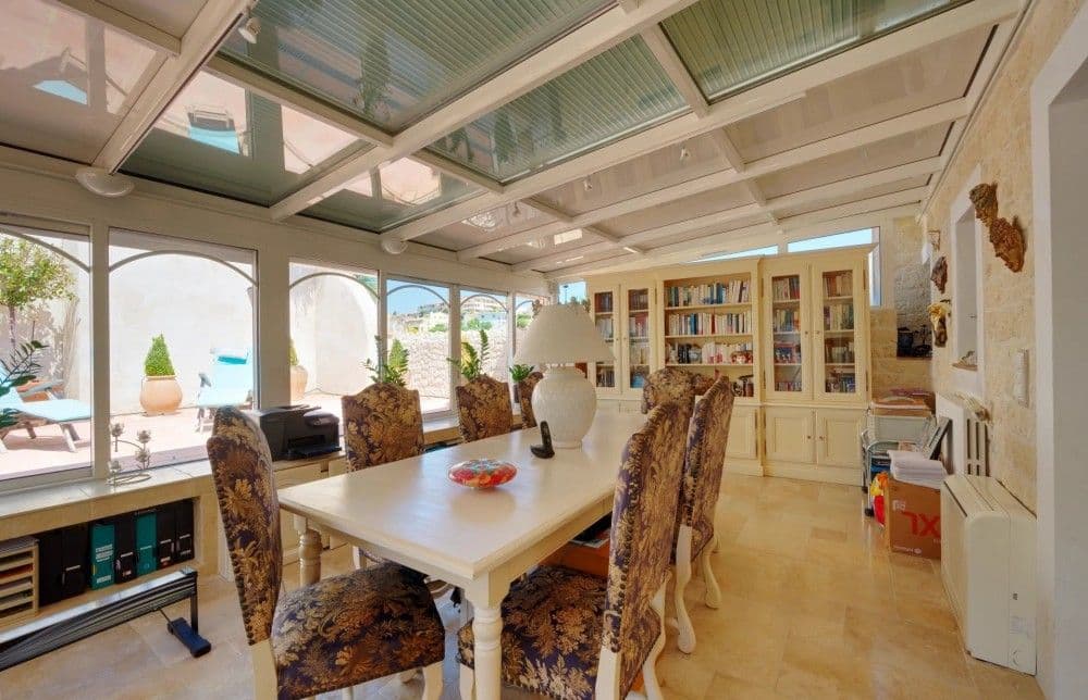 Dining room in a glazed conservatory with built-in shelving, 3-bedroom villa in Fabron, Nice