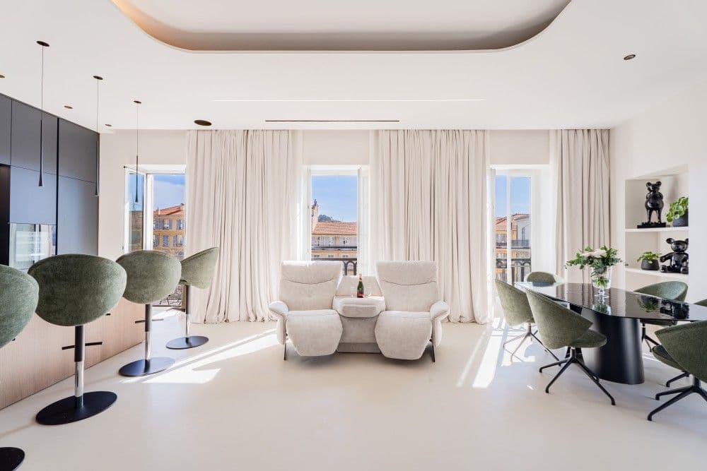 Renovated living room with green velvet chairs and tall windows, 3-bedroom apartment in Wilson, Nice