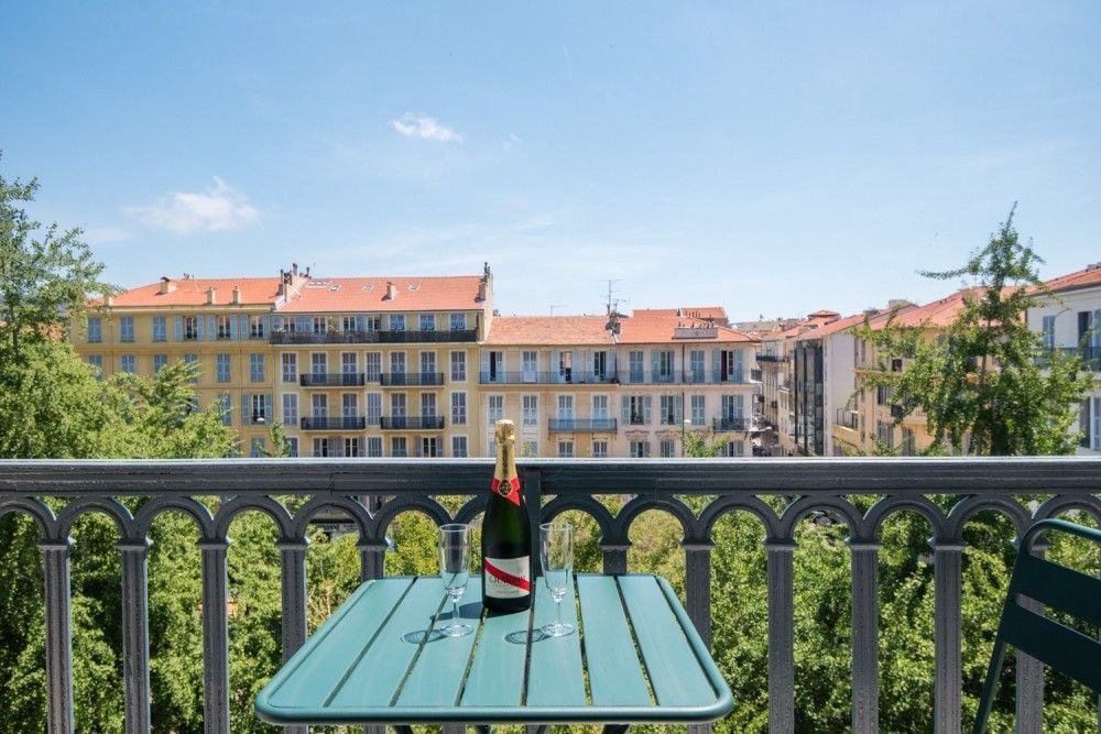 Balcony table and a view of the leafy street and façades, 3-bedroom apartment in Wilson, Nice