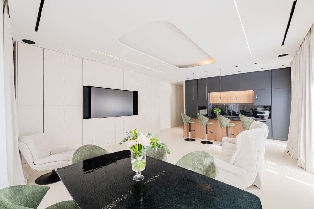 Living space with dining table and black kitchen wall, 3-bedroom apartment in Wilson, Nice