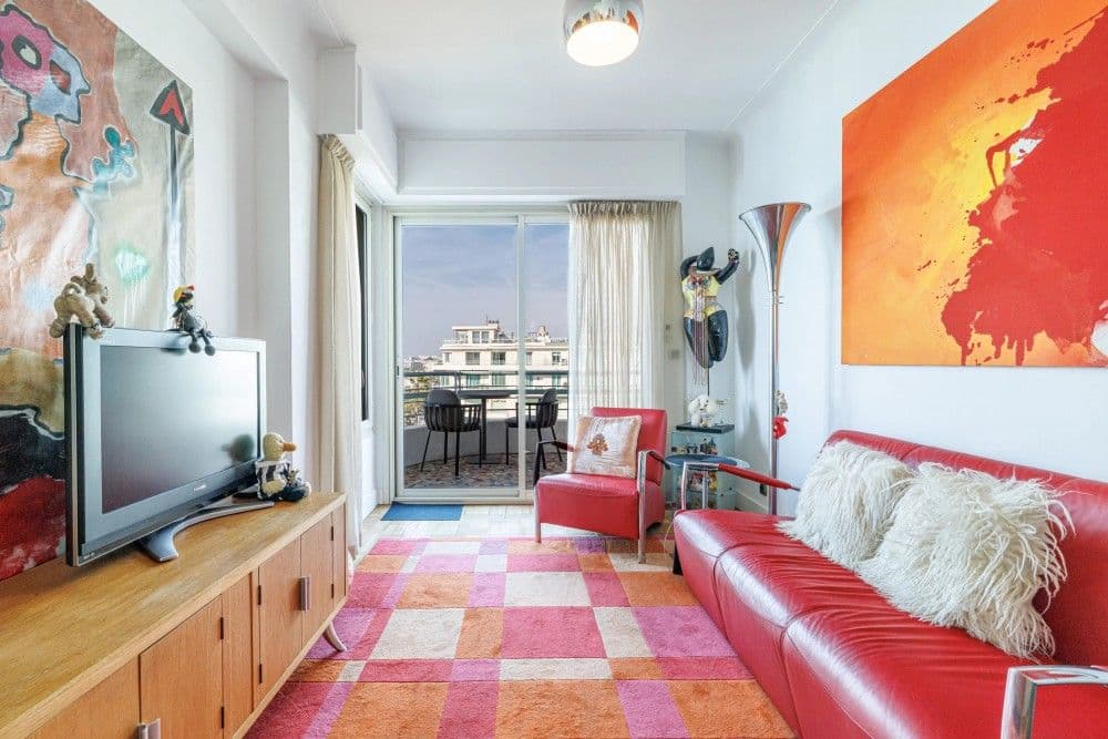 Living room with red leather sofa and checked rug, 3-bedroom apartment in the Promenade des Anglais, Nice