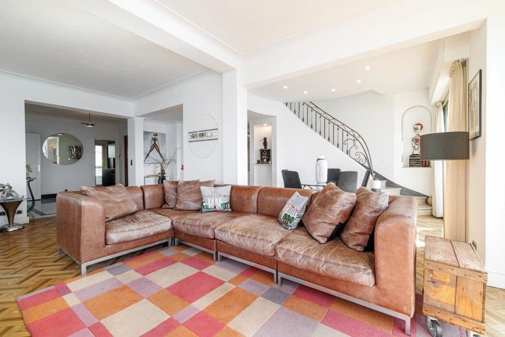 Living room with leather corner sofa and staircase, 3-bedroom apartment in the Promenade des Anglais, Nice