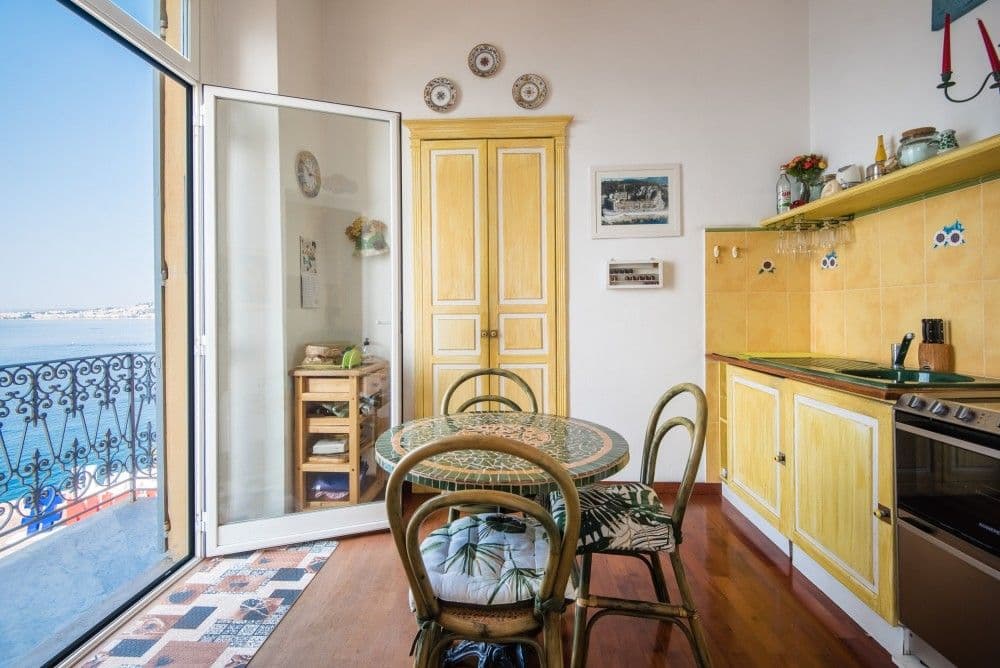 Kitchen with round table and French window to a sea-view balcony, 3-bedroom apartment in the Promenade des Anglais, Nice