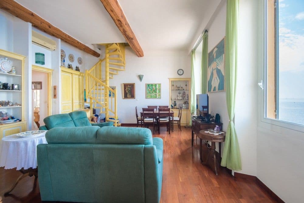 Living room with spiral staircase and windows over the sea, 3-bedroom apartment in the Promenade des Anglais, Nice