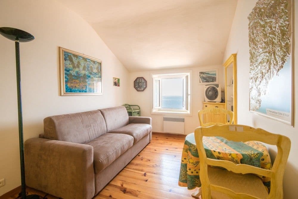 Sitting room with sofa and a small sea-view window, 3-bedroom apartment in the Promenade des Anglais, Nice