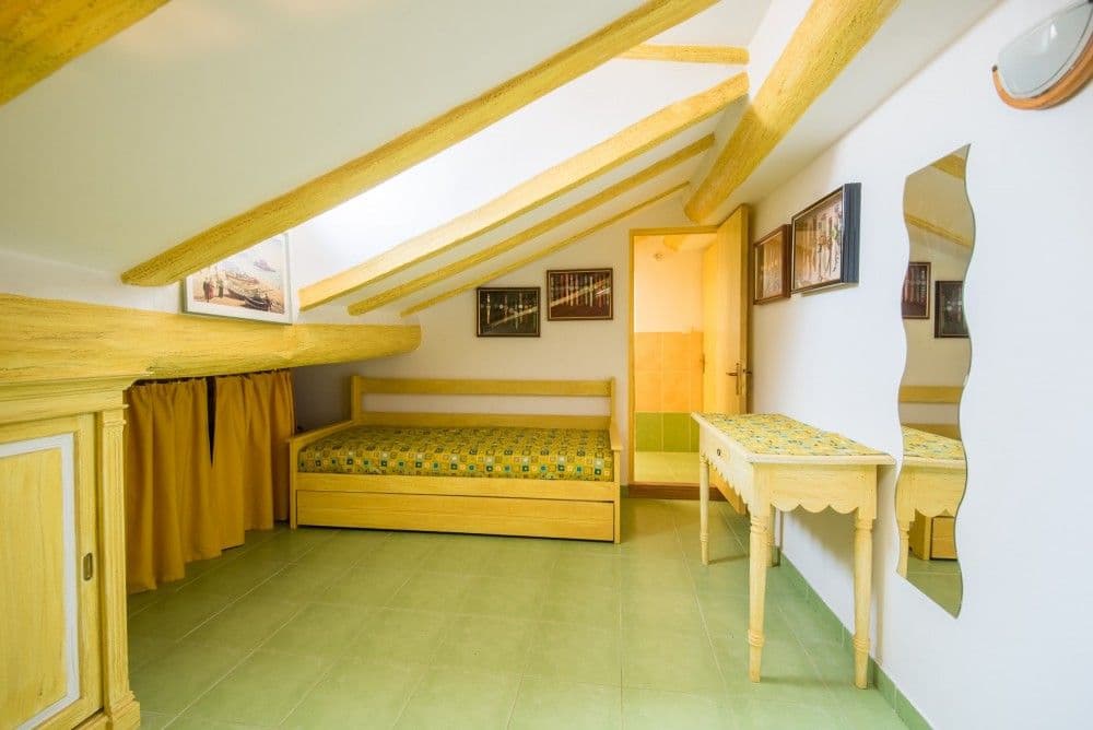 Attic bedroom with exposed beams and single bed, 3-bedroom apartment in the Promenade des Anglais, Nice