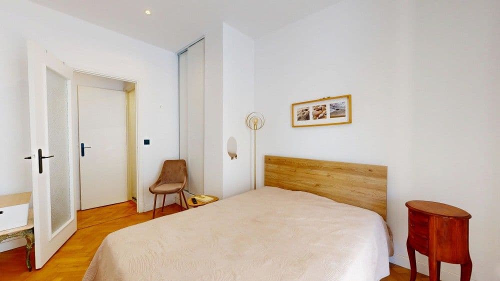 Bedroom with wooden headboard and parquet floor, 1-bedroom apartment in the Promenade des Anglais, Nice