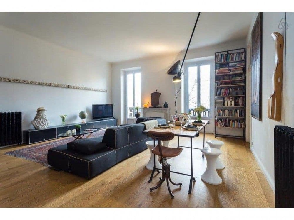 Living room with bookshelves, tall windows and wooden floor, 2-bedroom apartment in central Nice