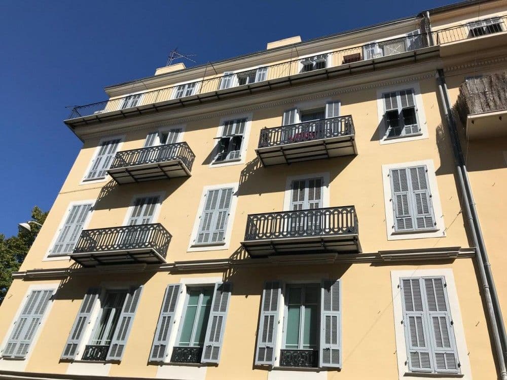 Yellow façade with wrought-iron balconies and grey shutters, 2-bedroom apartment in central Nice