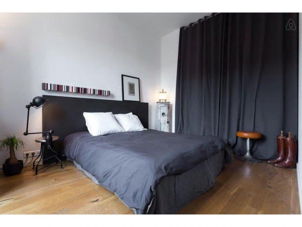 Bedroom with dark headboard, double bed and full-length curtains, 2-bedroom apartment in central Nice
