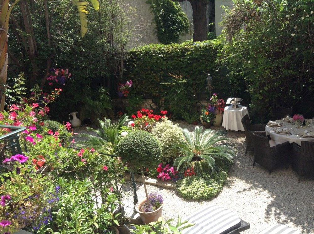 Flowering garden with shrubs and outdoor dining table, 2-bedroom apartment in central Nice