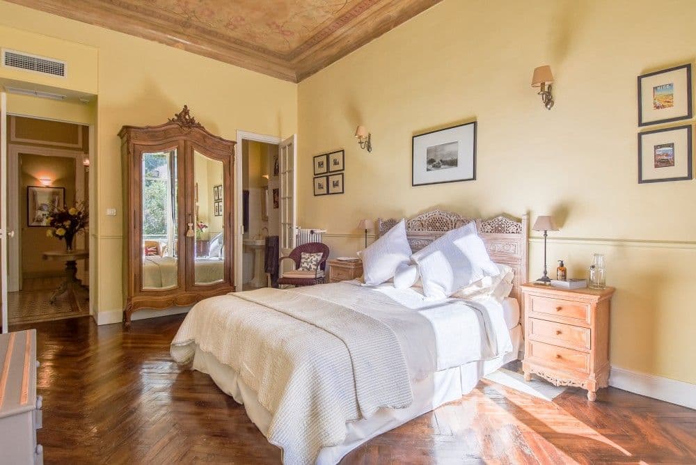 Bedroom with painted ceiling, carved headboard and antique wardrobe, 2-bedroom apartment in central Nice