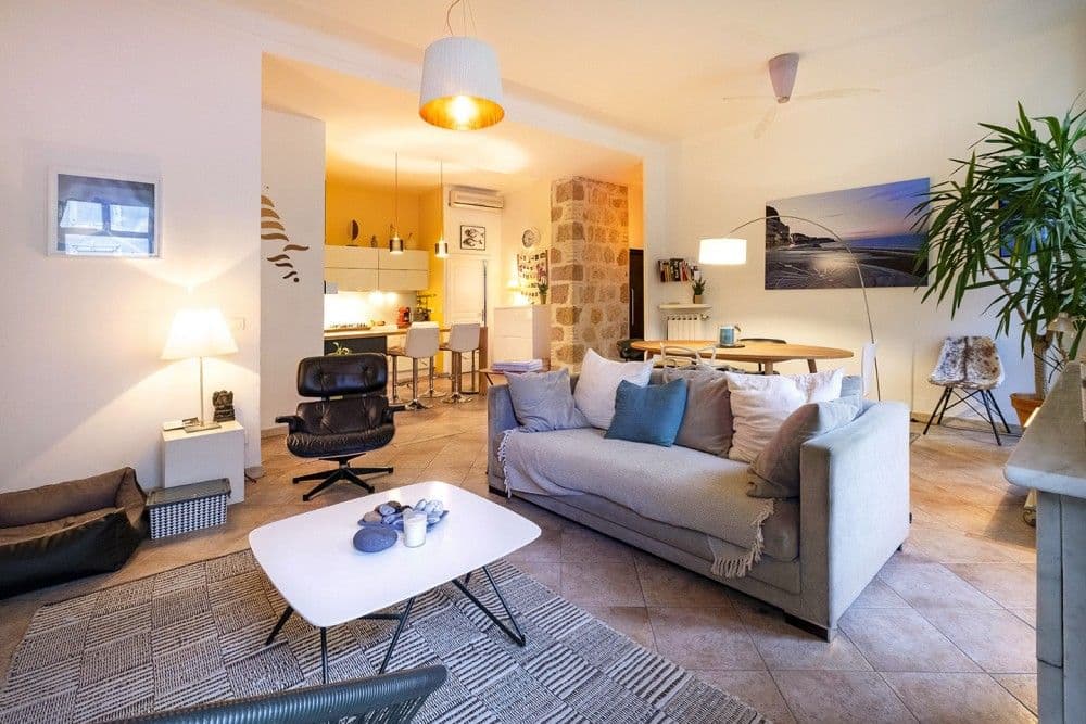 Open living space with Eames-style armchair and kitchen beyond, 3-bedroom apartment in the Port, Nice