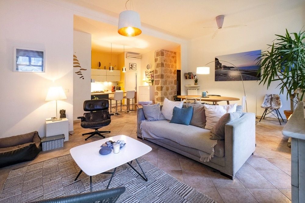Open living space with Eames-style armchair and kitchen beyond, 3-bedroom apartment in the Port, Nice