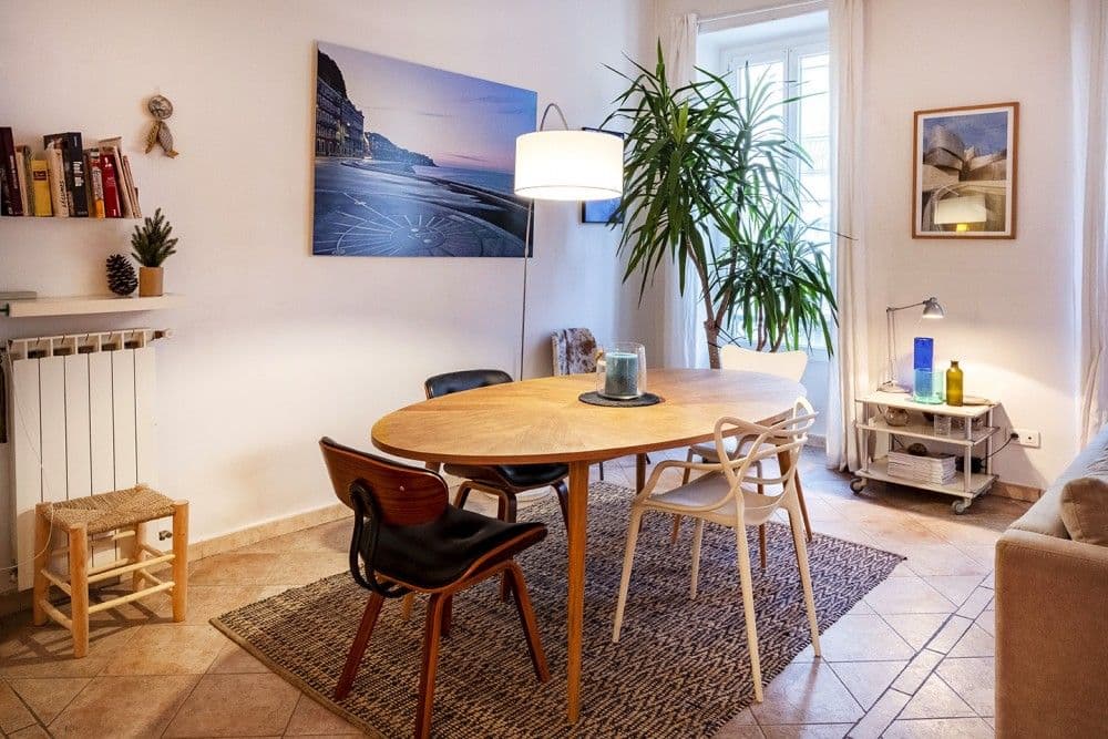 Dining area with round wooden table and tall window, 3-bedroom apartment in the Port, Nice