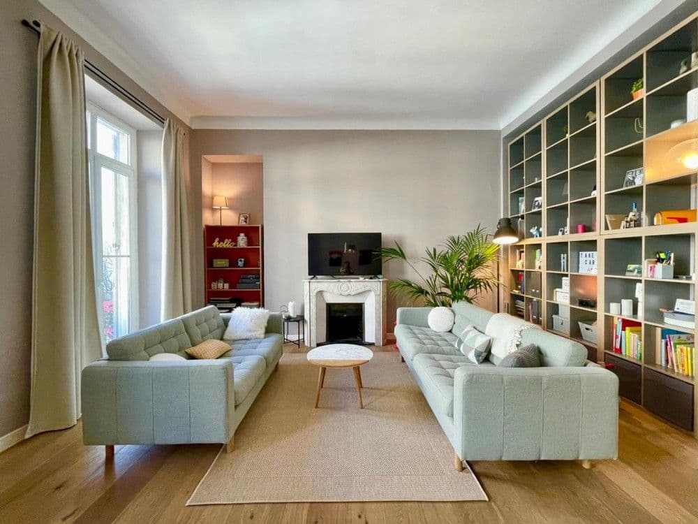 Living room with built-in bookshelves, fireplace and oak floor, 2-bedroom apartment in Nice