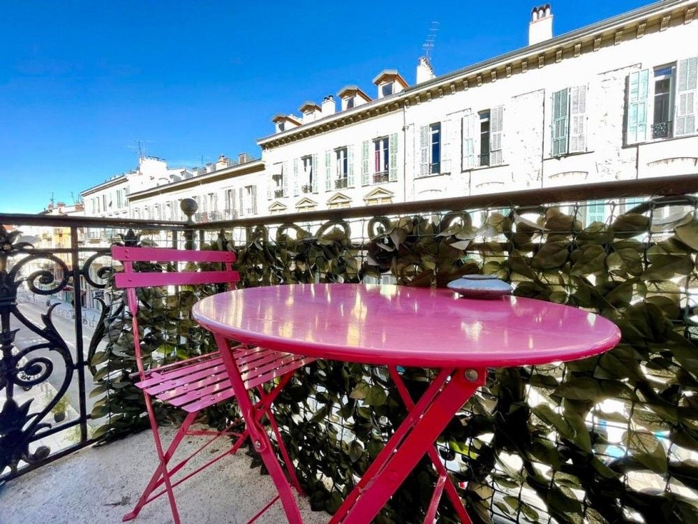 Balcony with pink bistro table and wrought-iron railing, 2-bedroom apartment in Nice