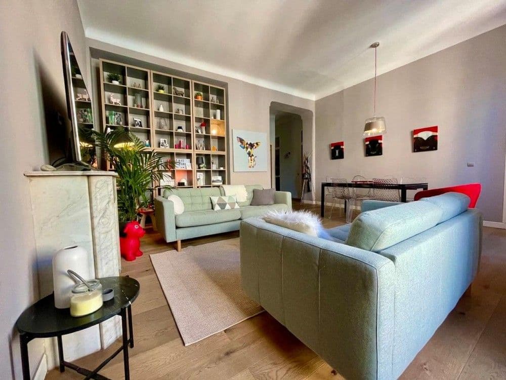 Living room with sofas, bookshelves and dining area, 2-bedroom apartment in Nice