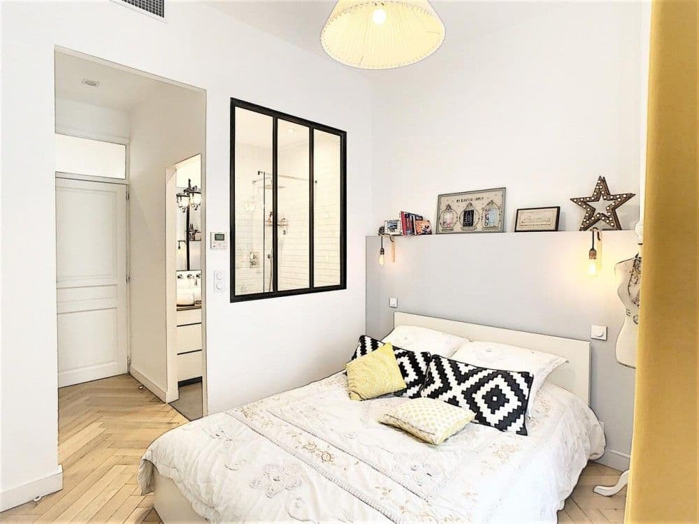 Bedroom with glass partition, double bed and yellow curtains, 3-bedroom apartment in Nice