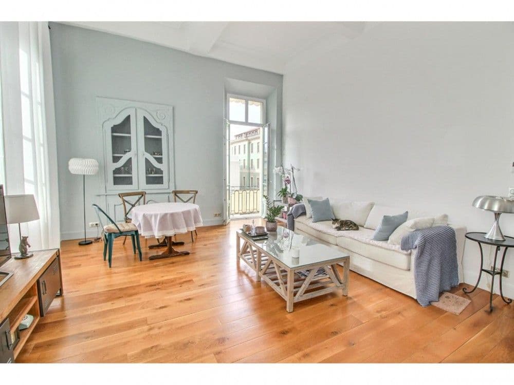 Living room with sofa, dining table and tall windows, 2-bedroom apartment in the Old Town, Nice