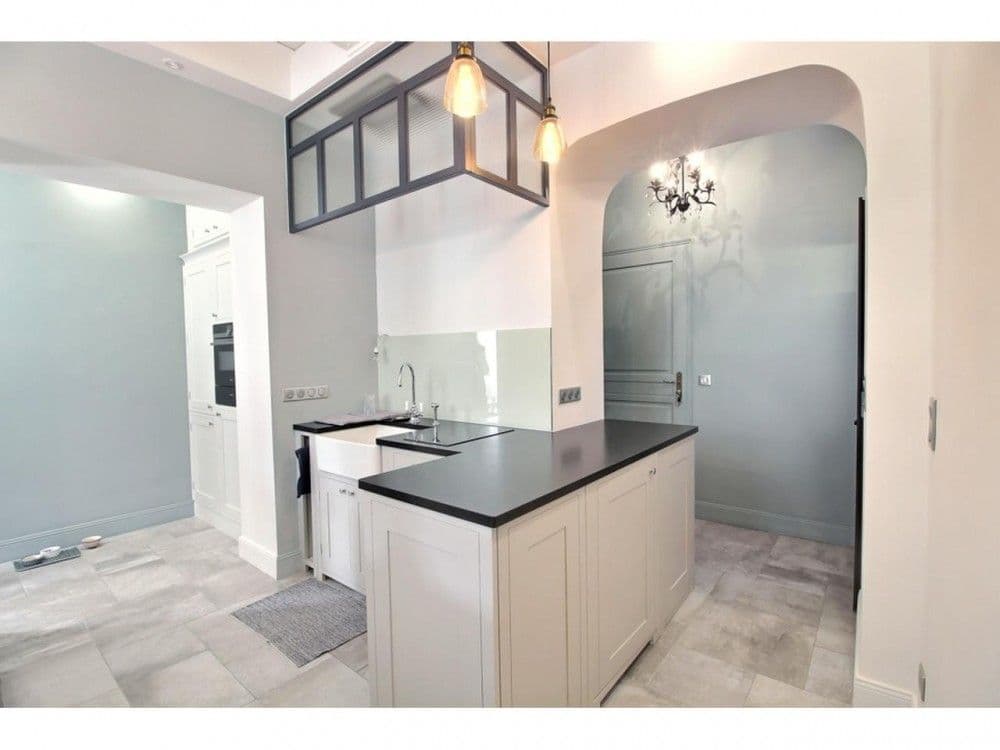 Kitchen island with black worktop and arched doorway, 2-bedroom apartment in the Old Town, Nice