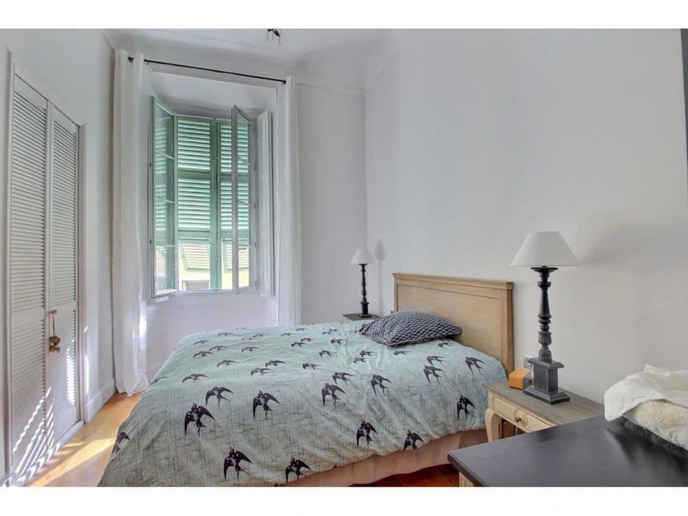 Bedroom with shuttered window and wooden headboard, 2-bedroom apartment in the Old Town, Nice