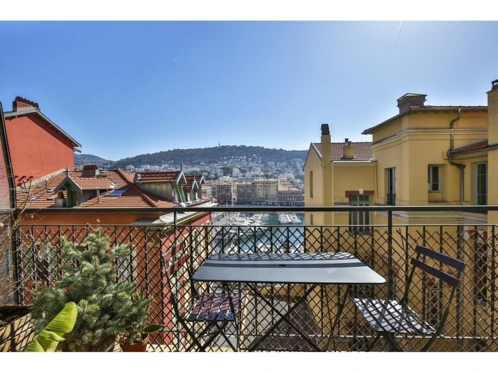 Balcony with table and chairs and a view over the rooftops to the hills, 2-bedroom apartment in the Port, Nice